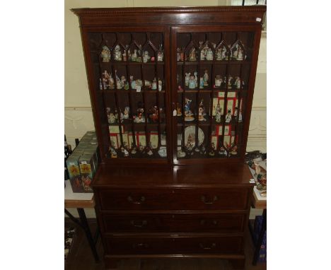 A George III style inlaid mahogany secretaire bookcase, having a pair of bar glazed doors above a secretaire drawer with two 