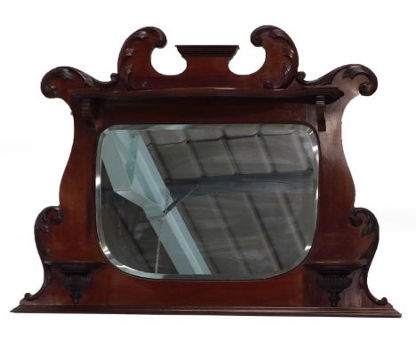 An early 19thC mahogany overmantel mirror, with a shaped crest above a shelf and an oval bevel plate, with further demi-lune 