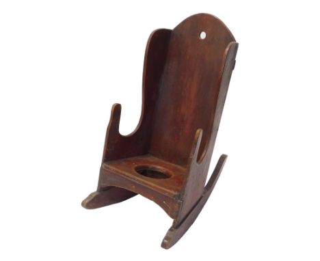 A 19thC country made child's red stained pine commode rocking chair, with shaped back.
