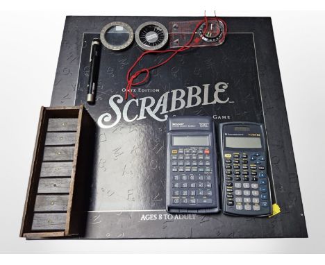 An onyx edition Scrabble game, two calculators, set of Dominoes, compass, laser pen, etc.