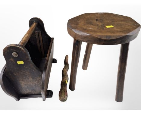 A Yorkshire-style oak tripod stool, together with a magazine rack and a carved rattlesnake.