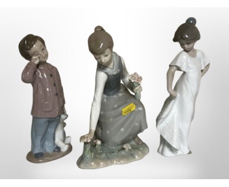 A Lladró figure of a girl picking flowers and two Nao figures of children, tallest 22cm.