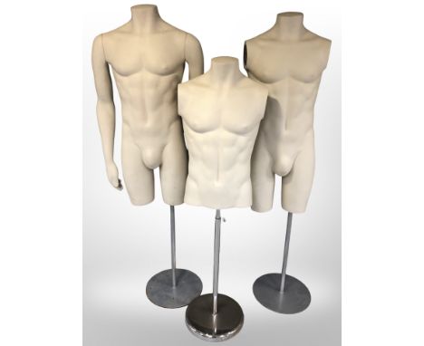 Three male mannequin torsos on stands