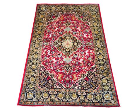 FINE PURE SILK PERSIAN TEHRAN DESIGN RUG, 210cm x 131cm, central medallion on a ruby field of hunting scenes within correspon