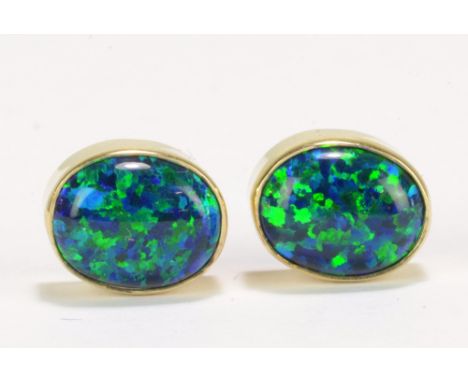 A pair of 9ct yellow gold black opal oval ear studs.