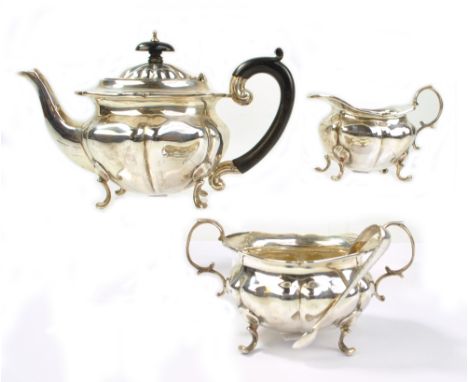 GEORGE UNITE; a George V hallmarked silver three piece bachelor's tea set comprising a shaped oval teapot on four C-scroll le