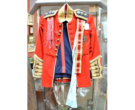 A British Army officer's dress/mess uniform comprising red coatee with Prince of Wales feathers and 'Juncta In Uno Tria' pips