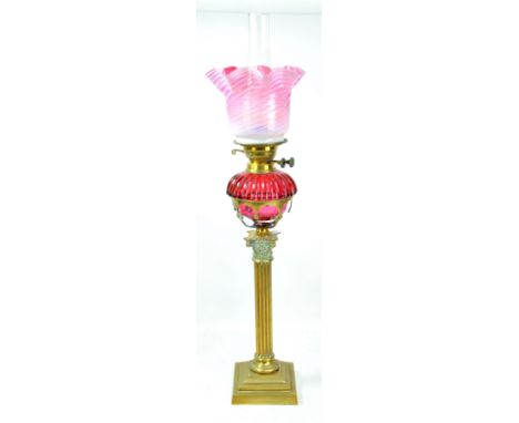 A late Victorian brass oil lamp with Corinthian column base, cranberry tinted cut glass reservoir and pink opaline shade, hei