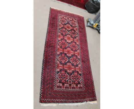 A Middle Eastern red ground carpet with stylised decoration, approx 220 x 173cm, a smaller rug and a runner (3).