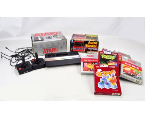 An Atari 2600 with two joysticks and manual, seven video games to include 'Ms. Pac-Man', 'Desert Falcon' and 'Midnight Magic'