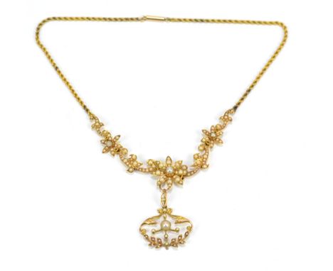 An Edwardian yellow metal necklace set with cultured freshwater seed pearls in floral arrangement on rope twist chain suspend