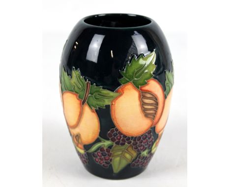 MOORCROFT; a 'Blackberries and Apricot' pattern vase of ovoid form on navy ground, with impressed marks and date cipher for 1