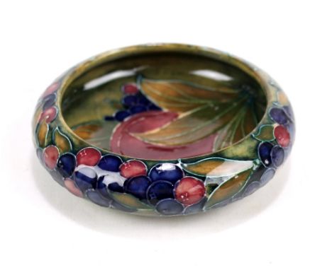 MOORCROFT; a 'Pomegranate' pattern tubeline decorated dish with William Moorcroft signature to base, diameter 10.8cm.Addition