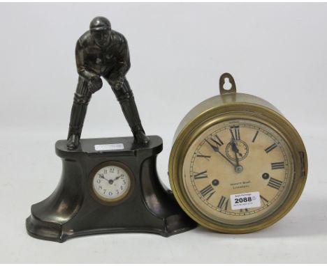 A metal mantel clock with wicket keeper finial, height approx 30cm, and a brass cased ship's clock with dial stamped for 'Mor