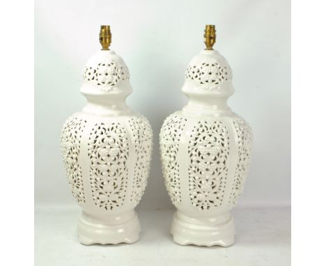 A pair of white glazed porcelain foliate scroll reticulated baluster lamp bases, height 50cm excluding fitment.