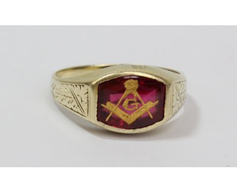 A 14ct yellow gold Masonic ring, gilt decorated with compass and square to the red platform and with engraved detail to the s