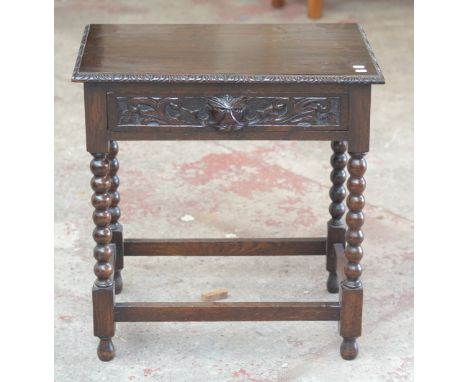 A carved oak side table raised on bobbin turned supports, width 69cm.