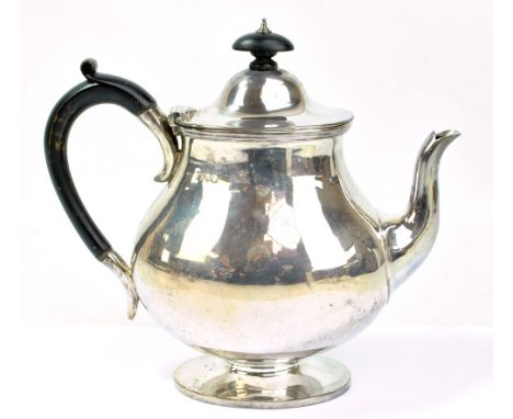 BREWIS &amp; CO; a Victorian hallmarked silver footed teapot of oval baluster form with ebonised handle and finial, height 22