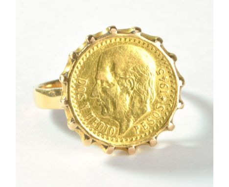 A Mexican 2 1/2 pesos gold coin converted to a ring with high claw soldered setting and yellow metal band with indistinct mar