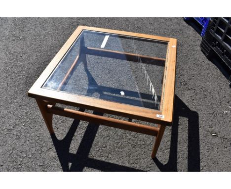 A vintage teak and glass top coffee table having stylised frame, approx 74 x 74cm