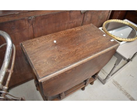 An early 20th century oak drop leaf gate leg dining table