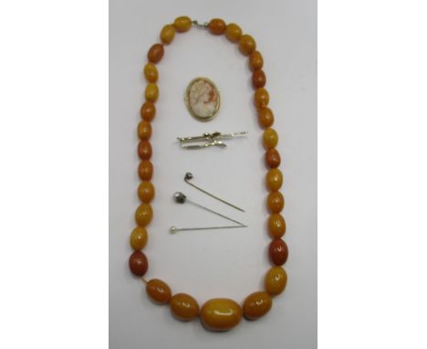 Graduated butterscotch amber beaded necklace, 76.45g, a 9ct gold cameo brooch stamped 375, 5.58g, three metal pins and a Stra