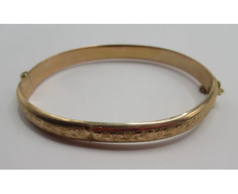 9ct yellow gold hinged bangle, half engraved with foliage detail, stamped 375, AF, 7.44g
