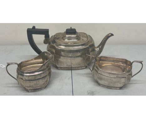 George V silver three piece tea service incl teapot with ebonised handle and finial, double handled sugar bowl and milk jug b