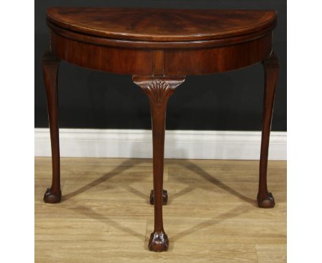 A George II style mahogany demilune card table, hinged top with segmented veneers enclosing a baize lined playing surface, st