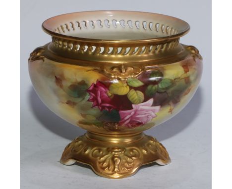 A Royal Worcester pot pourri vase, painted with pink and red cabbage roses, applied gilt scrolls, quatrefoil bases, pierced r