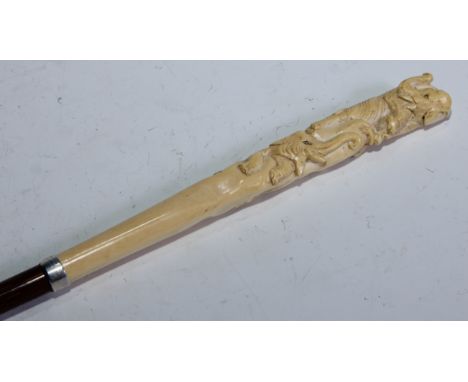 A Japanese novelty ivory and silver-mounted bamboo walking stick, the long tapering handle totem-carved with elephants and mo