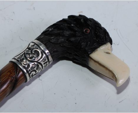 A late Victorian novelty silver-mounted ebony, ivory and bamboo walking stick, the handle well-carved as an eagle's handle, f