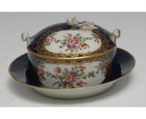 A Worcester butter tub cover and stand,  of circular shape, painted with flower surrounded by an elaborate gilt border on a w