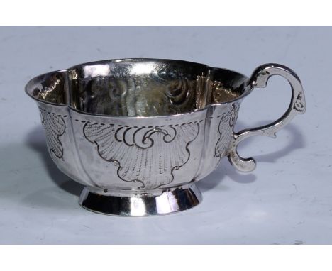 An 18th century Russian silver lobed oval vodka tot, cast and chased with flowering C-scrolls, skirted base, S-scroll handle,