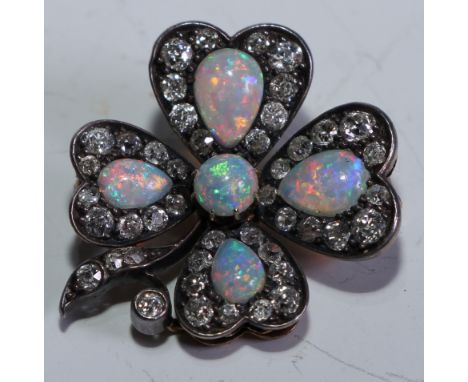 A fine quality opal and diamond brooch, the four petal setting inset with a single round cut and four pear drop opals, flashi