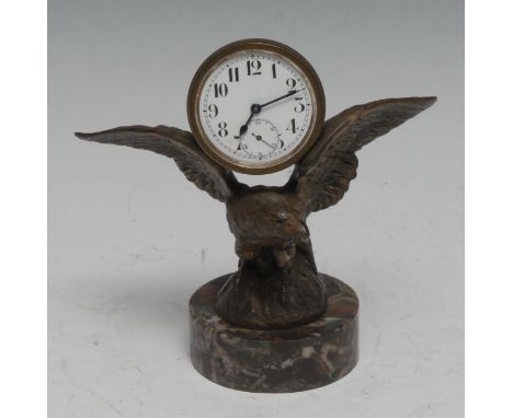 A novelty desk timepiece, of Empire influence, the composed structure as a 4.5cm white enamel 'clock' surmounting an eagle's 