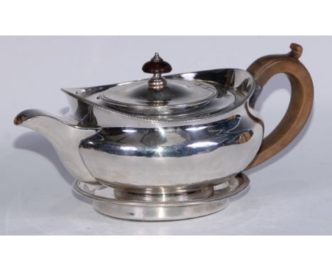 A Regency silver lamp shaped teapot and circular stand, flush-hinged domed cover, egg-and-dart border, scroll-capped fruitwoo