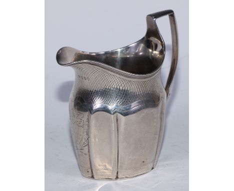 A George III silver commode shaped cream jug, bright-cut engraved with a shield shaped cartouche and wrigglework, angular scr