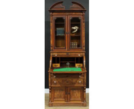 A late 19th century walnut accented dentist cabinet, the bookcase superstructure with broken arch pediment above a pair of gl