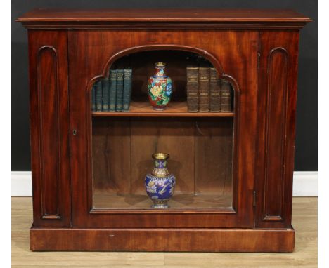 A Victorian mahogany pier bookcase or display cabinet, oversailing rectangular top above a glazed door enclosing a shelf, pli