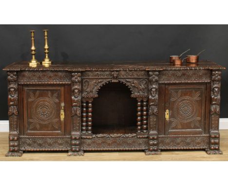 An 18th century oak low 'dog kennel' dresser, shaped rectangular top with inverted gadrooned edge, above an architectural cen