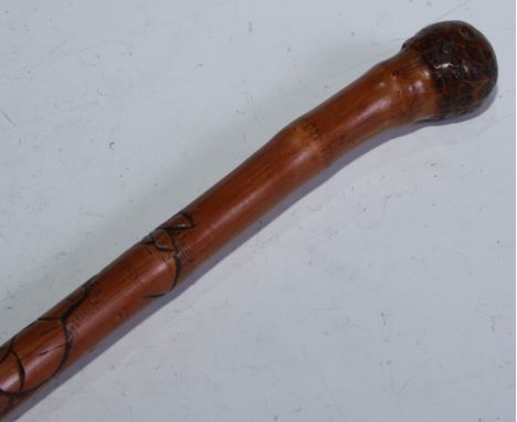 A Japanese bamboo walking stick, the cane shaft carved with figures, 83.5cm long, Meiji period 