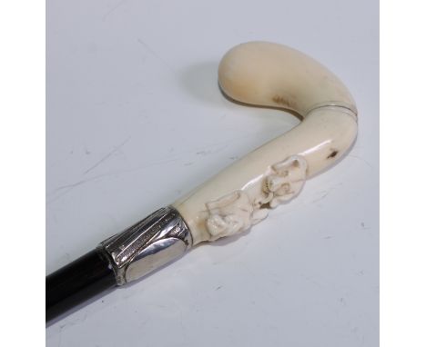 A late 19th century German gentleman's novelty marine ivory and horn walking stick, the club-shaped handle boldly carved with