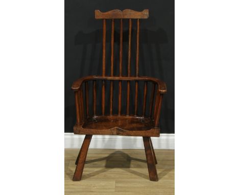 A George III style primitive comb-back Windsor chair, of West Country design, three-piece mid-rail, dished saddle seat, sprea