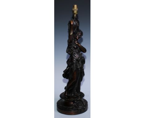 A late 19th century bronze figural table lamp, inspired by the antique, she stands holding a fluted urn in classical robes, s