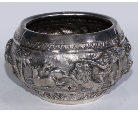 A Burmese silver bowl, chased in bold relief with a hunting scene, 16cm diam, c.1900, 652g 