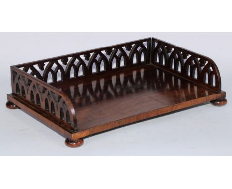 A George IV rosewood book trough, three-quarter gallery pierced with Gothic arches, bun feet, 40cm wide, book depth 24.5cm, c