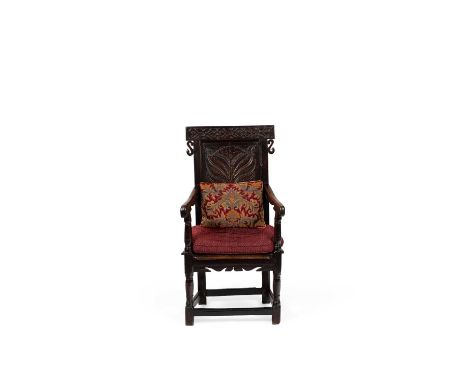 A James I oak armchair, West Country, boldly carved with a tree of life panel below strapwork top rail and S-scroll ears, 59c