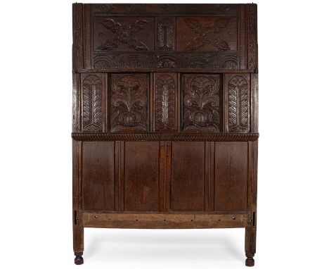 A late 17th Century oak tester headboard, alterations, carved with stiff leaf uprights, lunettes and trees within the recesse