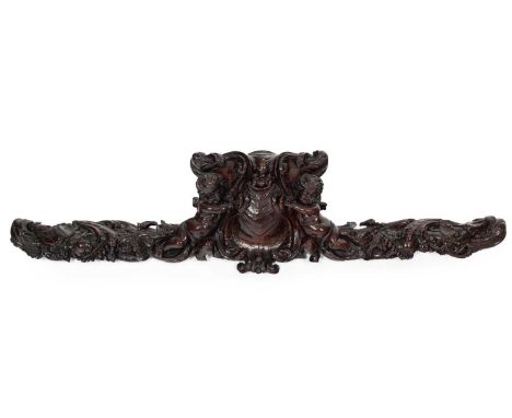 An 18th Century French carved walnut cresting, centred by a cartouche flanked by putti, 84cm long